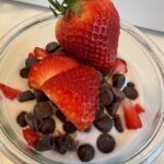 Picture of a jar of Strawberry Chocolate Chip Kefir Overnight Oats. Top is sprinkled with chocolate chips and fresh strawberries.