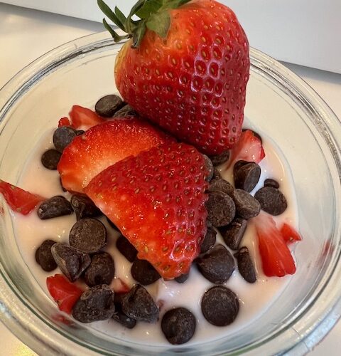 Picture of a jar of Strawberry Chocolate Chip Kefir Overnight Oats. Top is sprinkled with chocolate chips and fresh strawberries.